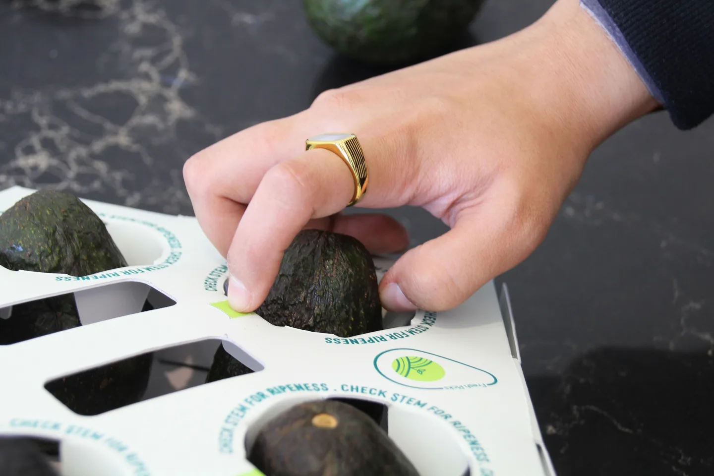 Lifting an avocado out through one of the perforated openings