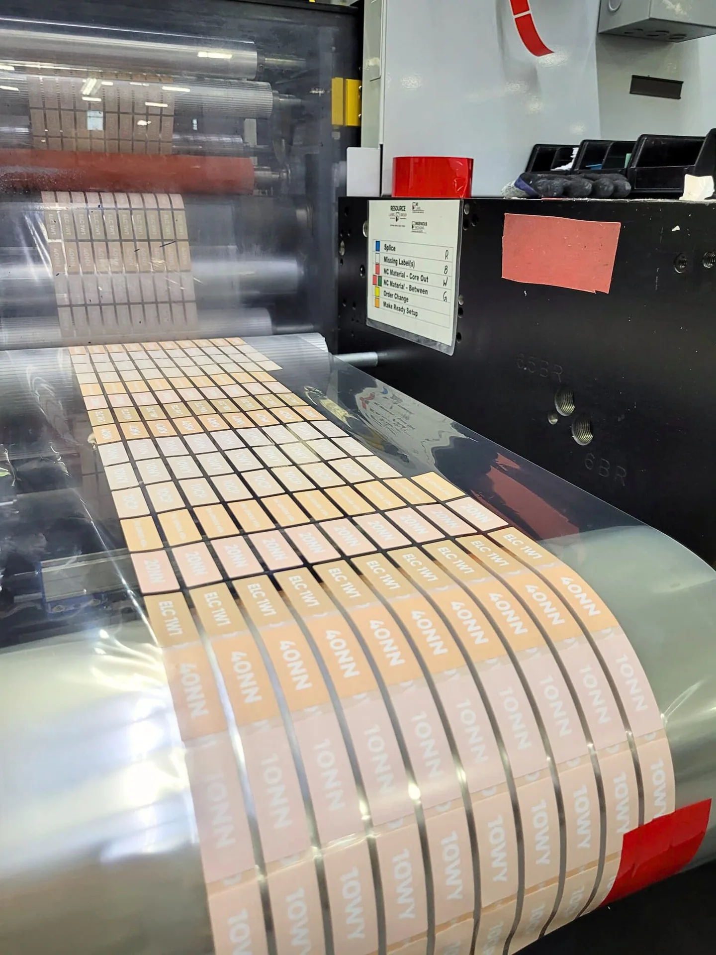 Rolls of printed foundation labels running through a flexo press
