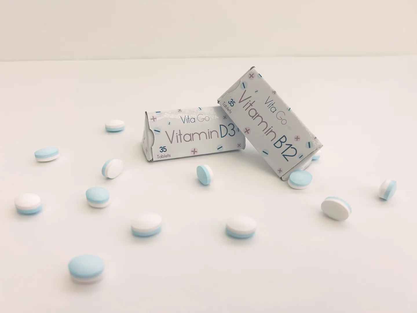Vitamin D3 and B12 triangular packs among scattered tablets